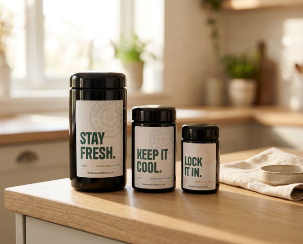3 miron storage jars all different sizes with custom labels, all on a light wood kitchen countertop, bright lighting.