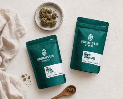 green bags on a cream background, with cbd flower on a plate, neutral lighting with cloth and spoon 