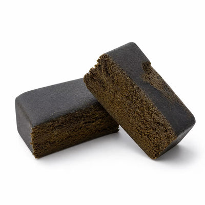cbd hash cut in half and placed on top of each other, white background.